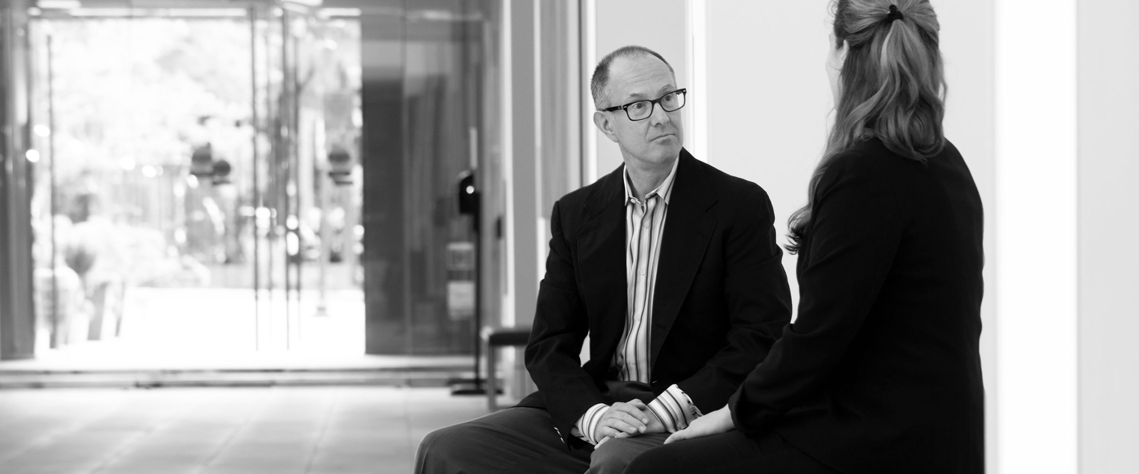 Joe Gitchell, CEO, speaking with someone while sitting on a bench.